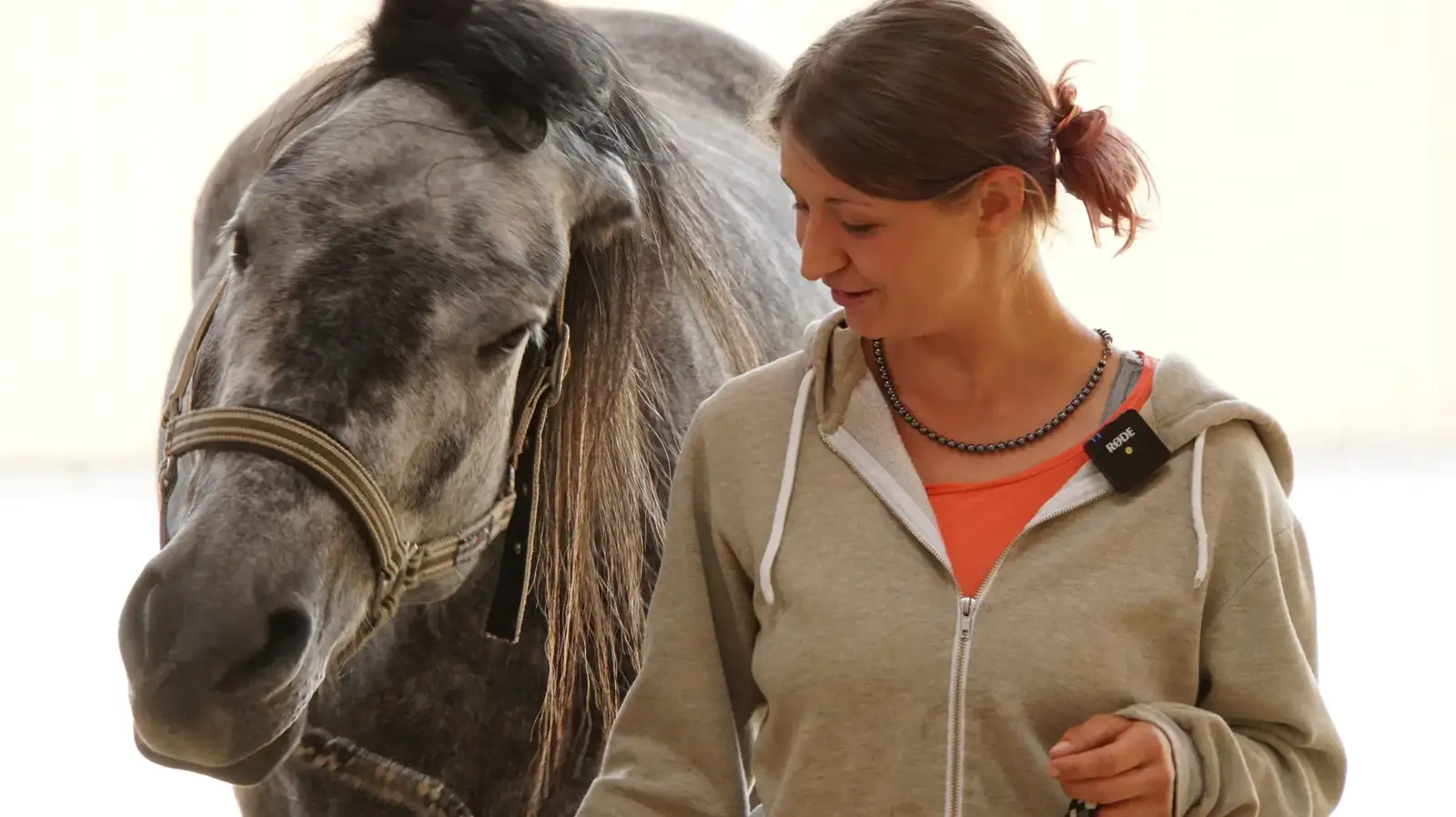 Loredana Bianculli steht dicht bei ihrem Schimmel und schaut ihn an